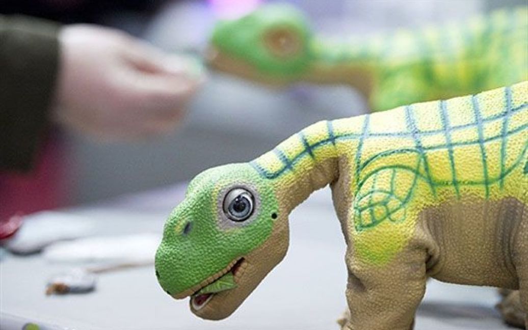 Німеччина, Ганновер. Іграшку робота-динозавра "Pleo" презентували на виставці CeBIT, найбільшому у світі ІТ-ярмарку, який проходить у Ганновері. Динозавр оснащений датчиками по всьому тілу, що дозволяє "Pleo" миттєво реагувати на зір, слух і дотик. / © AFP