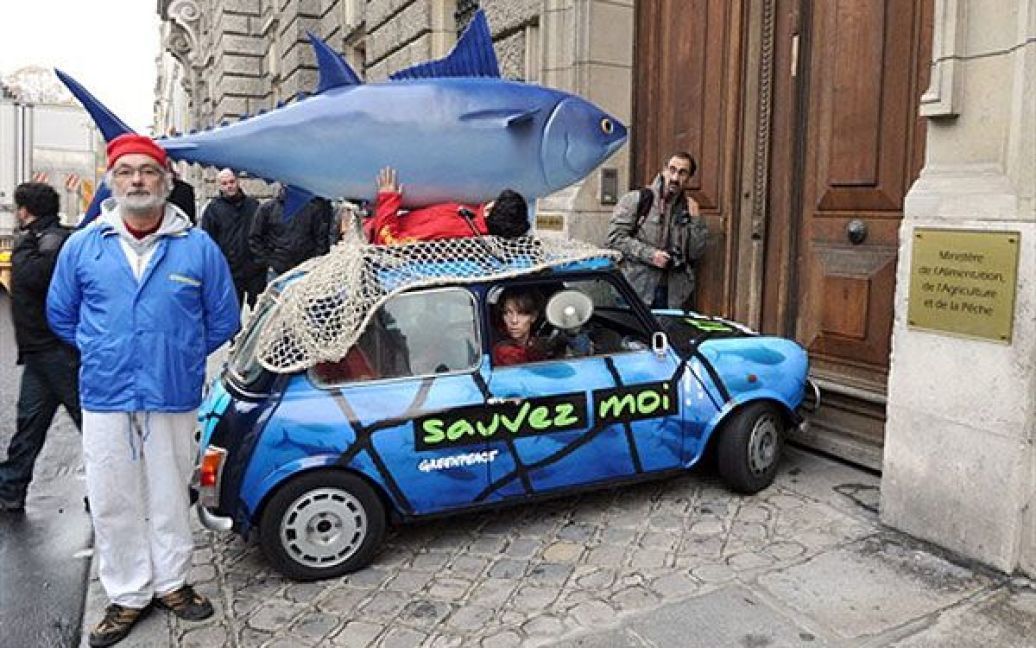 Франція, Париж. Активісти руху "Грінпіс" заблокували міністра риболовлі і сільського господарства Франції у Парижі. На машині з фігурою блакитного тунця на даху і плакатом "Допоможи мені" вони виступили проти позиції Франції з питання вилову блакитного тунця. / © AFP