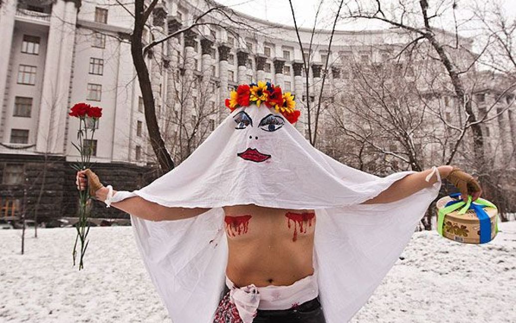 Активістка руху FEMEN в образі "кровосісі" спробувала прорватися до будівлі Кабінету міністрів і особисто вручити Миколі Азарову квіти і торт. / © Жіночий рух FEMEN