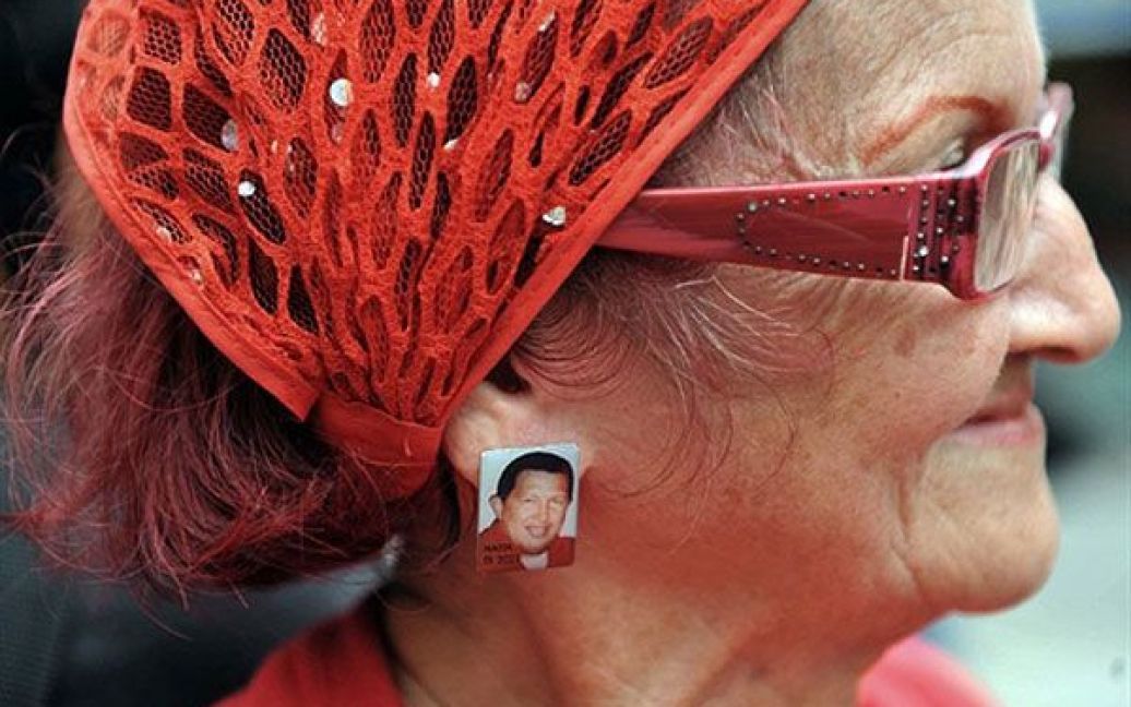Венесуела, Каракас. Прихильниця президента Венесуели Уго Чавеса одягла сережки з його зображенням на мітинг на його підтримку в Каракасі. / © AFP