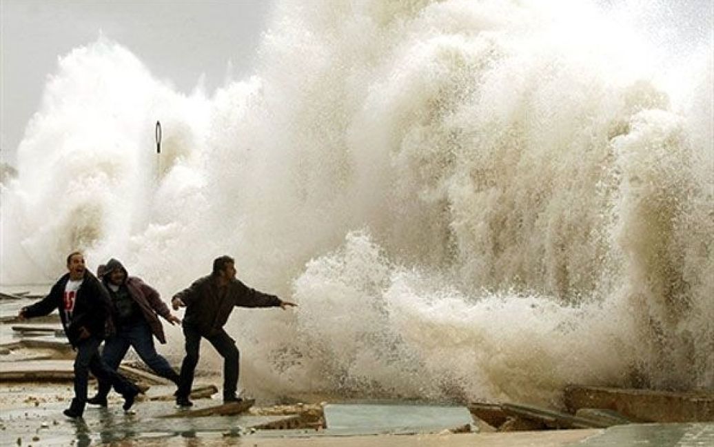 Ліван, Сидон. Ліванські чоловіки стоять перед величезними хвилями на набережній у місті Сидон. / © AFP
