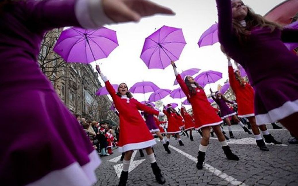 Португалія, Порто. Дівчата беруть участь у щорічному параді Санта Клаусів у центрі міста Порту. Тисячі учасників параду спробували побити рекорд Гіннеса з кількості людей у костюмі Санта Клаусів. / © AFP