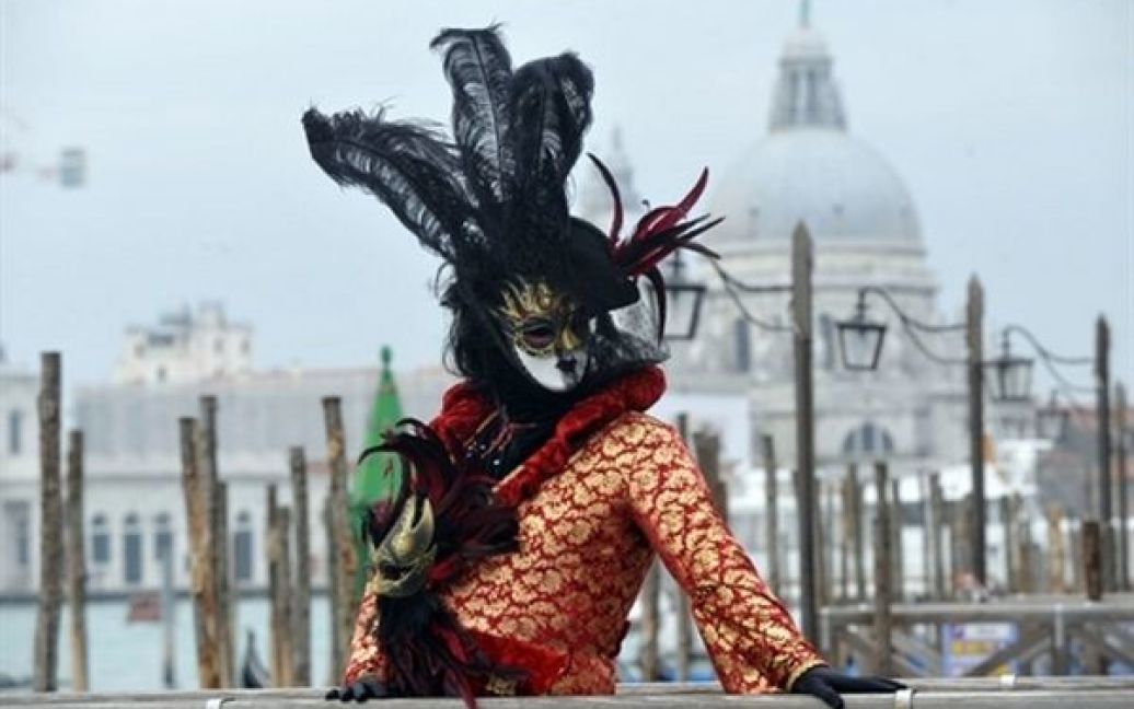 Італія, Венеція. Людина, одягнена у карнавальний костюм, бере участь у Венеціанському карнавалі на площі Сан-Марко у Венеції. / © AFP