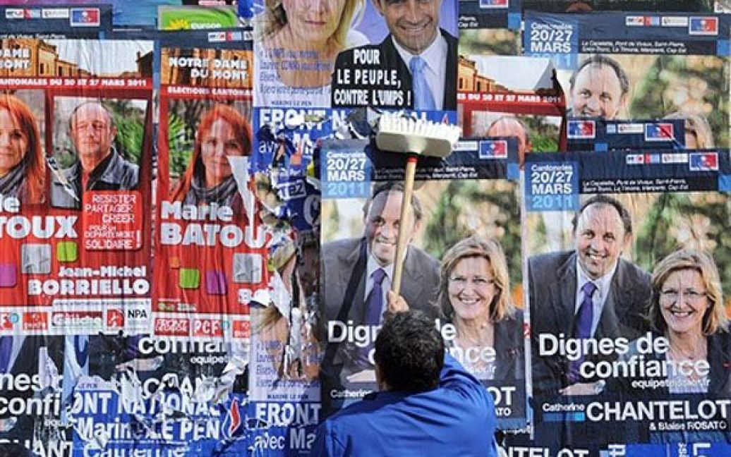Франція, Марсель. Чоловік розвішує виборчі плакати у Марселі напередодні проведення місцевих виборів 20 і 27 березня. / © AFP