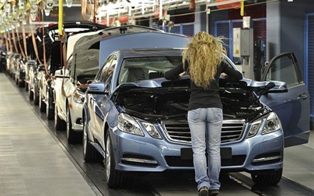 Німеччина, Зіндельфінген. Працівник закриває капот автомобіля Mercedes-Benz E-класу на останньому етапі перевірки на конвеєрі заводу Mercedes-Benz у Зіндельфінгені. / © AFP