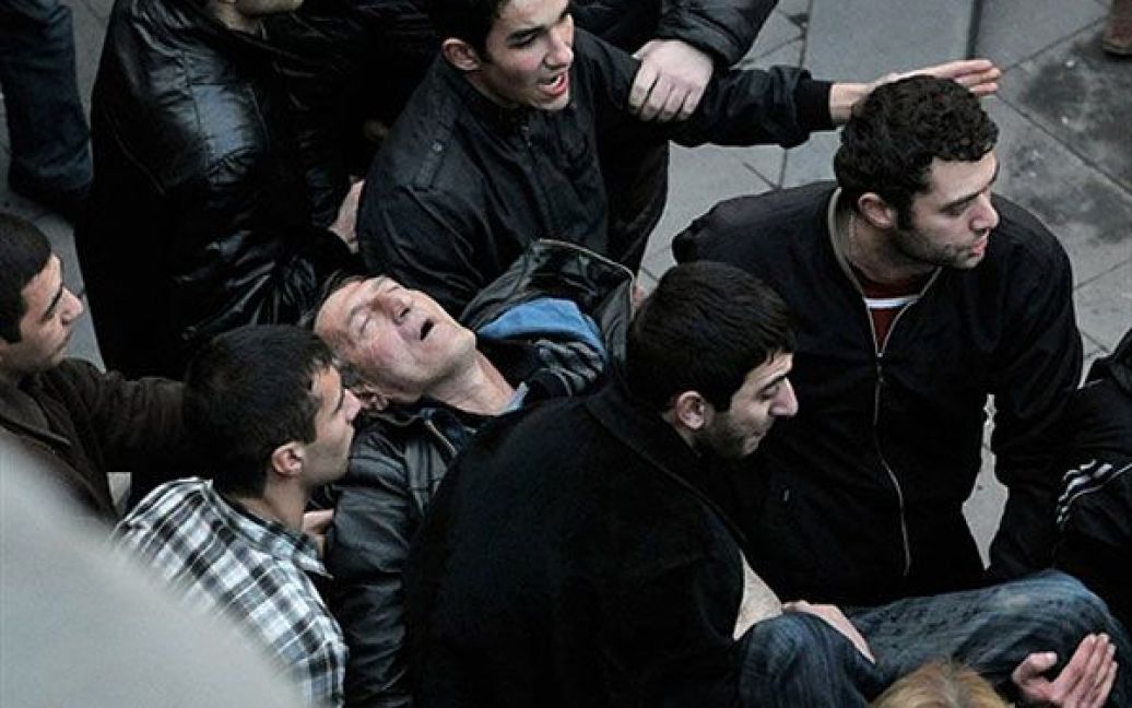 Вірменія, Єреван. Вірменські демонстранти допомагають нести чоловіка, який був поранений під час зіткнень з правоохоронцями на акції протесту у Єревані. Більше 10 тисяч прихильників опозиції закликали уряд країни піти у відставку. / © AFP
