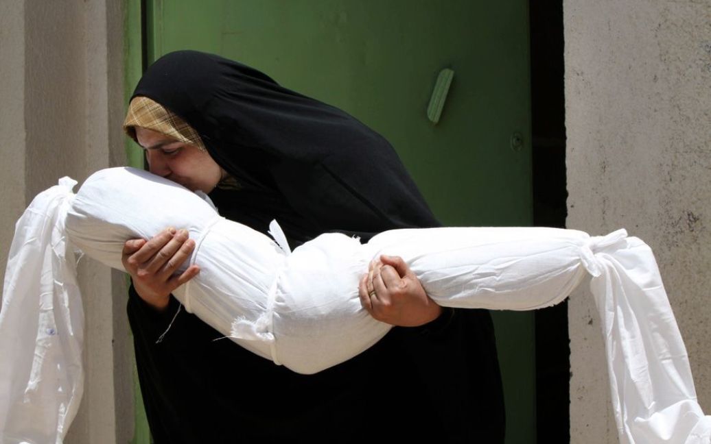 Жінка цілує спотворене тіло своєї 4-річної племінниці Зайнаб, яка загинула під час теракту у комерційній частині Багдада. (AP Photo / Alaa al-Marjani) / © The Boston Globe