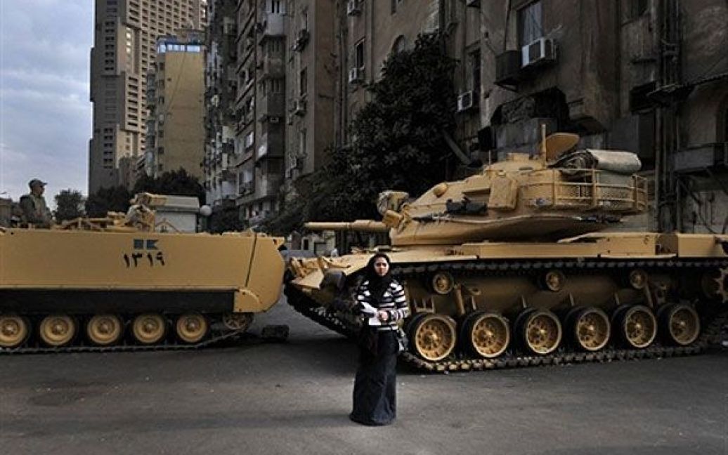 Єгипет, Каїр. Єгипетська жінка стоїть поруч із танками, які блокують вулицю перед будівлею єгипетського державного телебачення. У Каїрі коптські християни провели демонстрацію після того, як 13 людей загинули під час міжконфесійних зіткнень. / © AFP