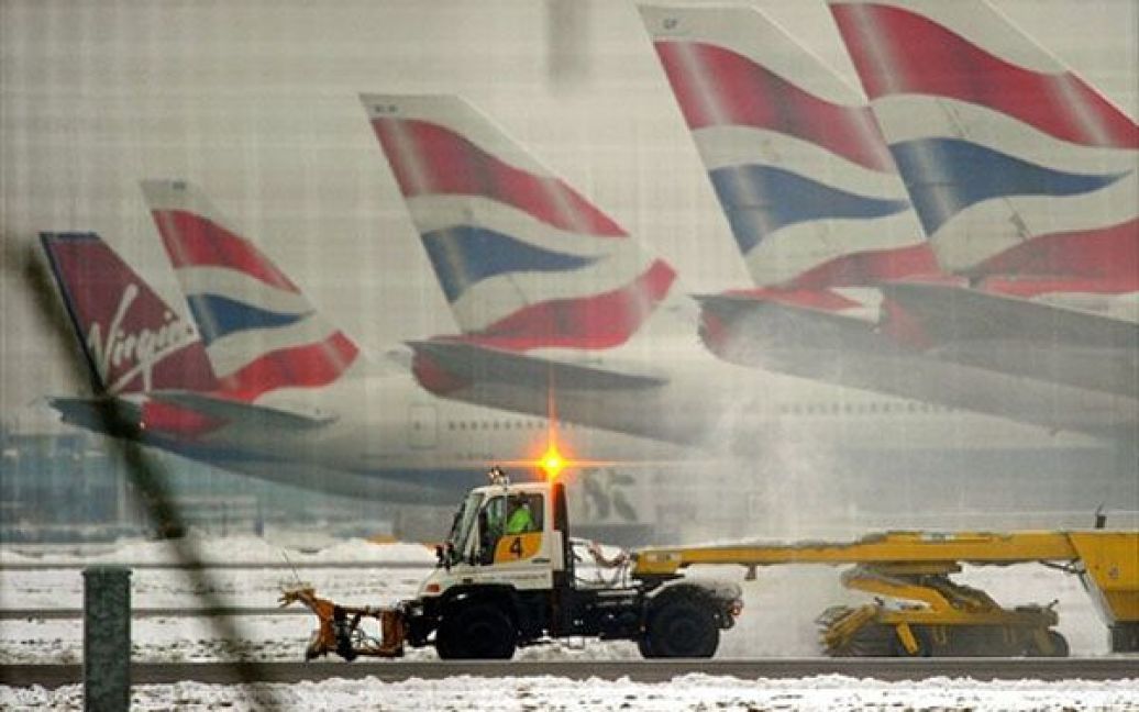 Великобританія, Лондон. Снігоочисник везуть на ремонт злітно-посадковою смугою в аеропорту Хітроу, на захід від Лондона. Нові снігопади, які обрушились на країну, зруйнували плани тисяч мандрівників по всій Європі. У лондонському Хітроу пасажири були вимушені спати на підлозі терміналів протягом чотирьох днів, оскільки було скасовано дві третини рейсів. / © AFP