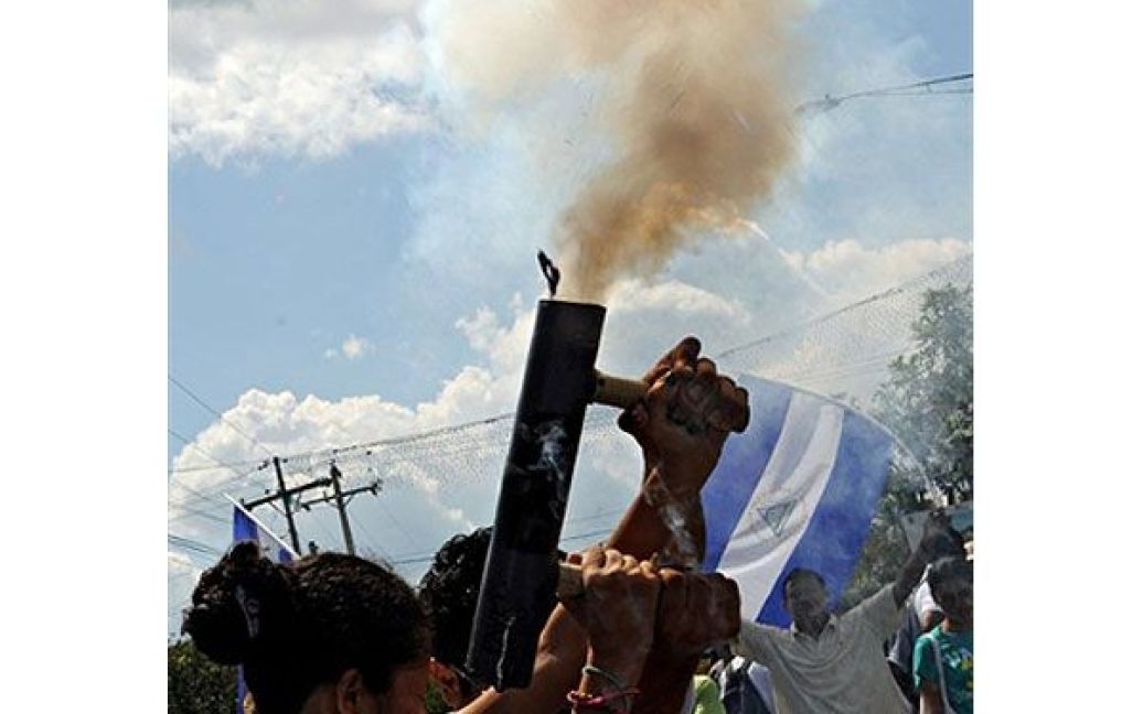 Нікарагуа, Манагуа. Жінка стріляє з саморобного міномету під час маршу нікарагуанських студентів і працівників, який провели в Манагуа. Тисячі людей вийшли на вулиці, щоб підтримати позицію уряду президента Даніеля Ортеги щодо прикордонної суперечки з Коста-Рікою. / © AFP