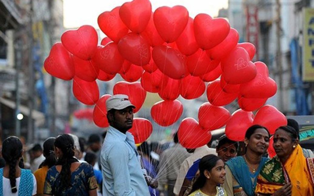 Індія, Хайдарабад. Індійський чоловік продає повітряні кульки у формі серця на ринку в Хайдарабаді. Уряд Індії оголосив про запровадження нових заходів з приборкання цін на продовольчі товари. / © AFP