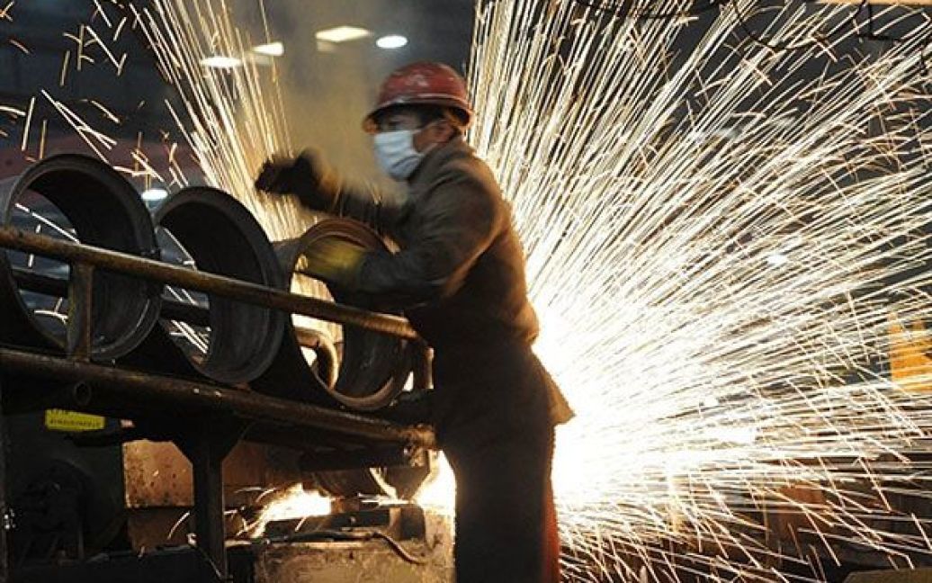Китай, Хефей. Китайський працівник на сталеливарному заводі у Хефеї, провінція Аньхой, східний Китай. / © AFP