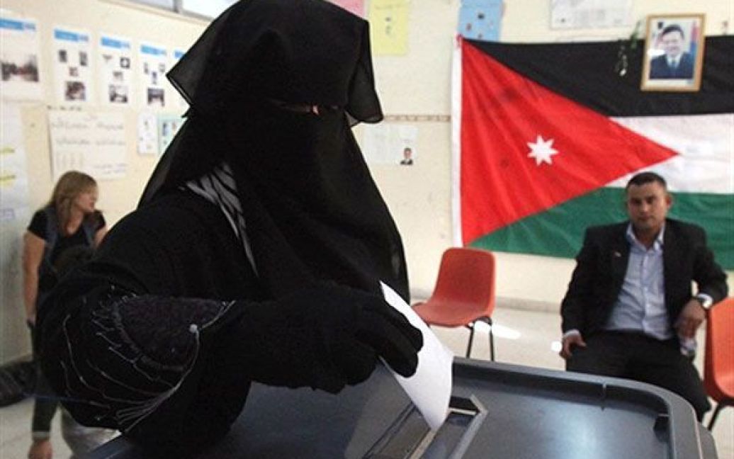 Йорданія, Амман. Завуальована йорданська жінка кидає бюлетень до урни під час голосування на виборчій дільниці у Аммані. У Йорданії пройшли дострокові вибори до уряду. / © AFP