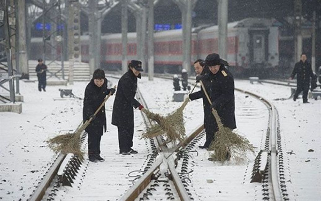Китай, Пекін. Працівники прибирають сніг на залізничній станції після першого снігопаду, який цього року пройшов у Пекіні. / © AFP