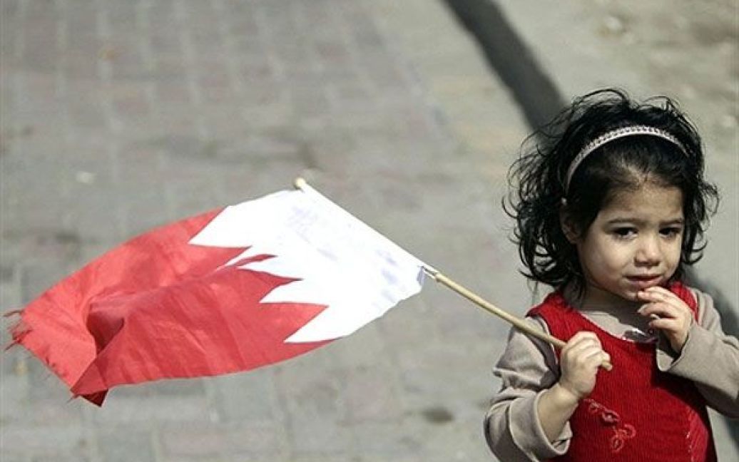 Бахрейн, Манама. Дівчинка тримає національний прапор під час багатотисячного мітингу на Перлиновій площи у Манамі, учасники якого вимагають зміни влади у країні. / © AFP