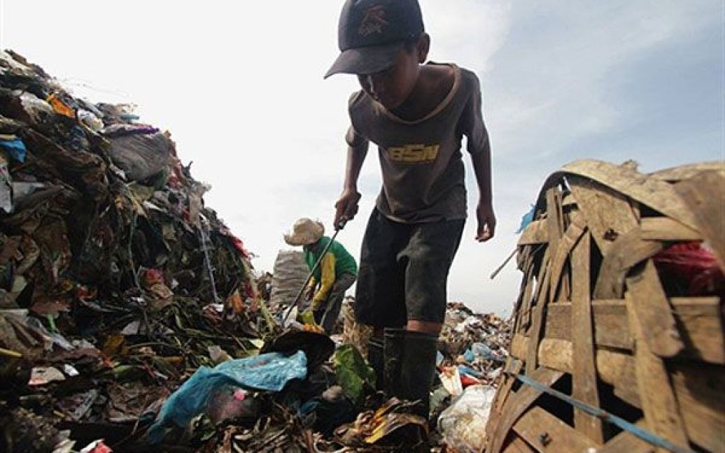 Індонезія, Медан. 12-річний Амрі шукає речі на звалищі у Медані, Північна Суматра. Амрі є восьмою дитиною з дев&#039;яти братів, які допомагають своїм батькам збирати сміття. / © AFP