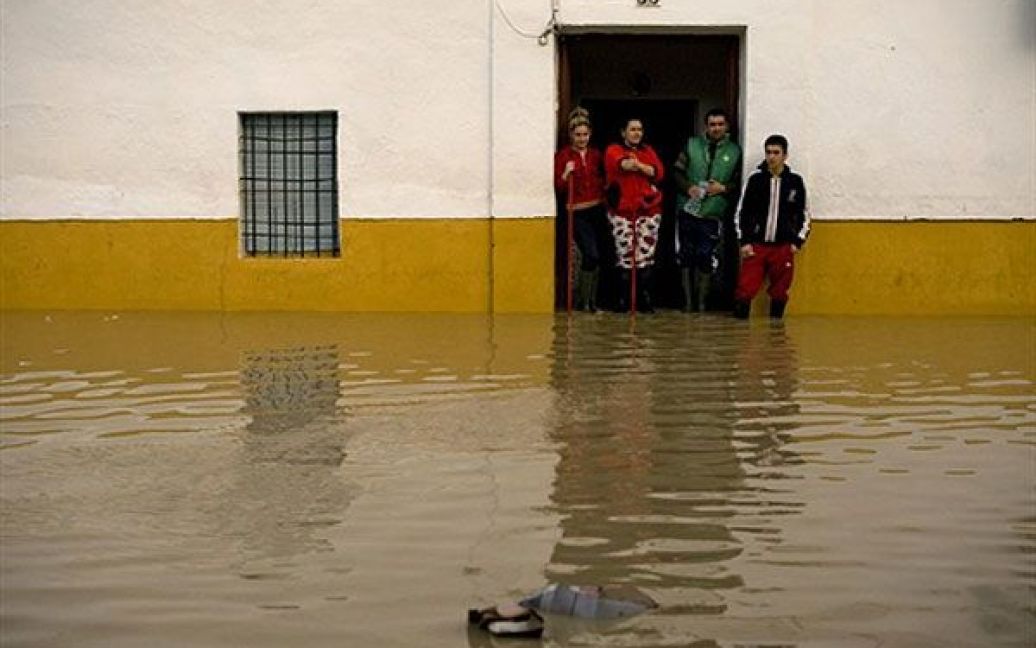 Іспанія, Есіха. Люди дивляться на вулицю, затоплену після кількох днів проливних дощів у містечку Есіха, поблизу Севільї, на півдні Іспанії. Сильні дощі викликали повені у кількох областях Іспанії. / © AFP