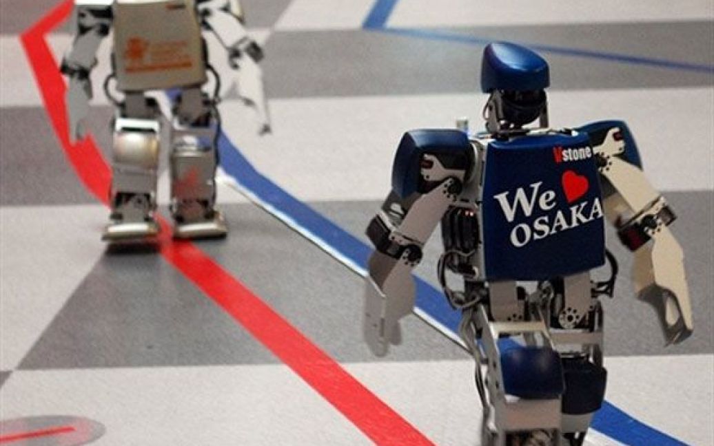 Японія, Осака. Робот-гуманоїд на ім&#039;я "Robovie-PC" та ще один робот беруть участь у першому всесвітньому повному марафоні для двоногих роботів у Осаці. Учасники першого марафону роботів повинні були подолати 42,195 км протягом чотирьох днів. Фото AFP PHOTO / HO / Vstone / © AFP
