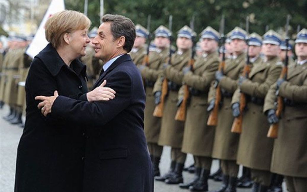 Польща, Варшава. Федеральний канцлер Німеччини Ангела Меркель і президент Франції Ніколя Саркозі вітають один одного під час прибуття до палацу Віланов у Варшаві на саміт Веймарського трикутника. / © AFP