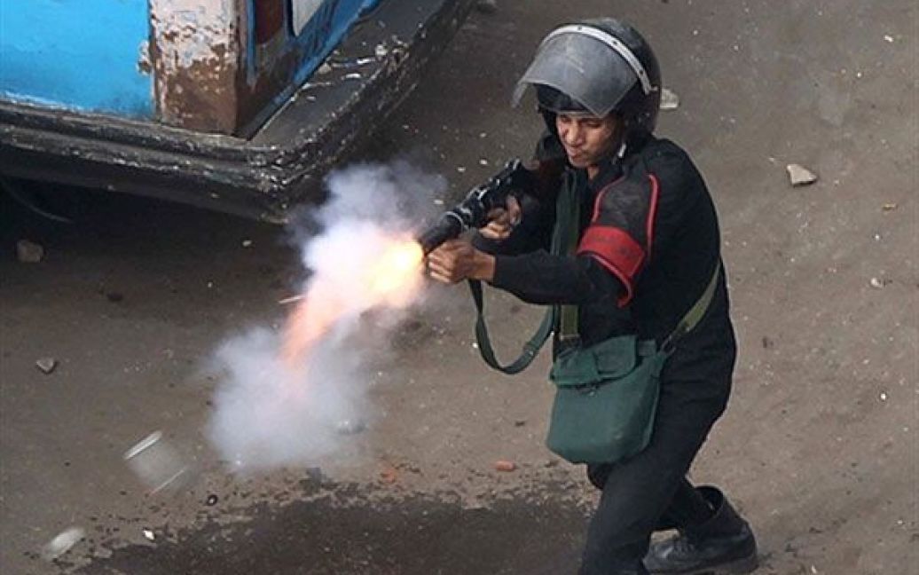 Єгипет, Каїр. Єгипетський поліцейський стріляє сльозогінним газом у демонстрантів під час акції протесту в Каїрі. Демонстранти вимагають повалення президента Хосні Мубарака. / © AFP