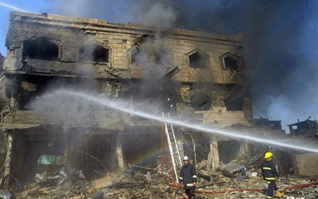 Ірак, Кіркуку. Пожежні гасять пожежу в будівлі, яка спалахнула після вибуху автомобіля у північному місті Кіркук. Три автомобілі вибухнули майже одночасно, в результаті вибуху загинули щонайменше вісім осіб. / © AFP