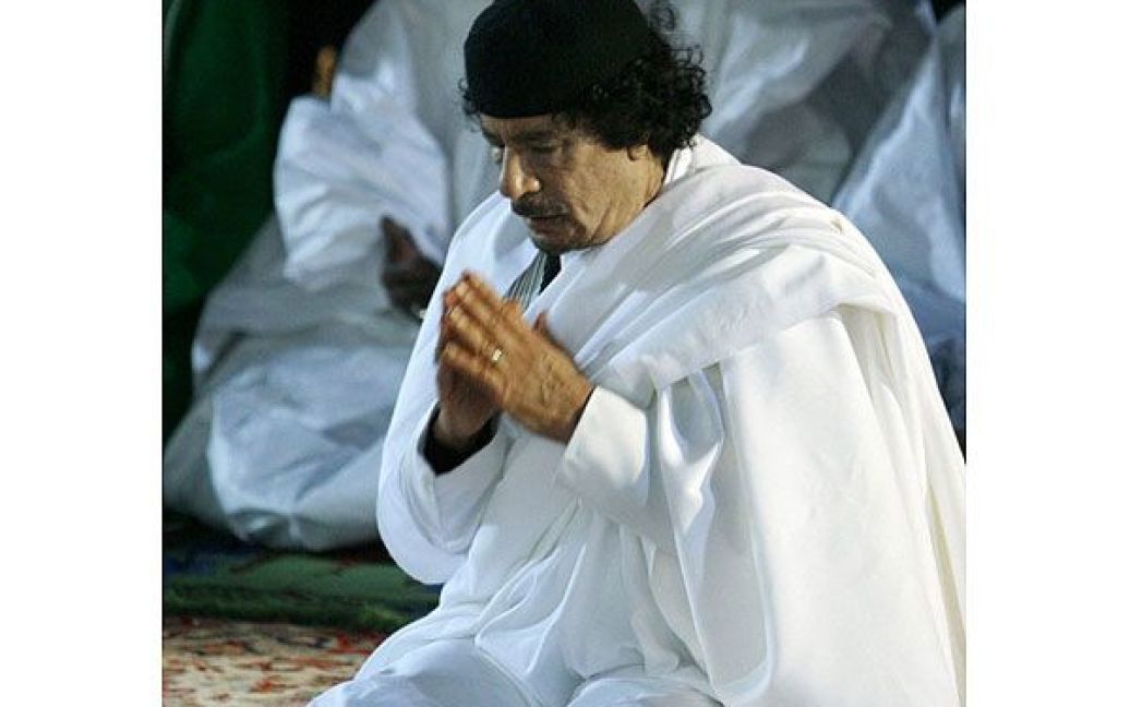Муаммар Каддафі молиться після виступу у місті Бенгазі, лютий 2010 року. / © AFP