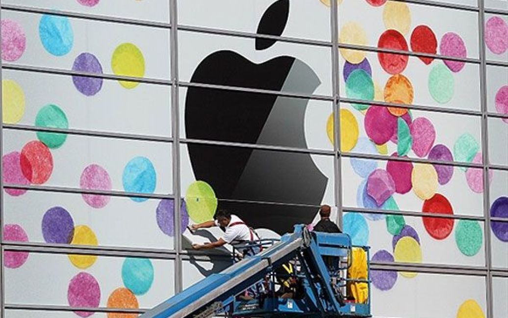 США, Сан-Франциско, штат Каліфорнія . Робочі встановлюють логотип "Apple" на стіні Центру мистецтв Yerba Buena у Сан-Франциско. Компанія "Apple" готує спеціальний захід до запуску IPad 2, який відбудеться 2 березня. / © AFP
