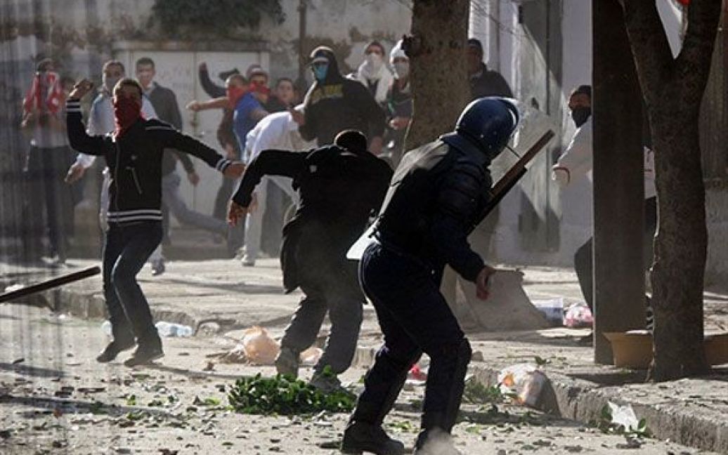 Алжир. Алжирські демонстранти кидають каміння під час зіткнень з поліцейським, які спалахнули у районі Белкур в центрі Алжира. Священнослужителі закликали алжирців до спокою під час п&#039;ятничної молитви, після того, як у місті піднялась хвиля протестів через зростання цін і безробіття. / © AFP