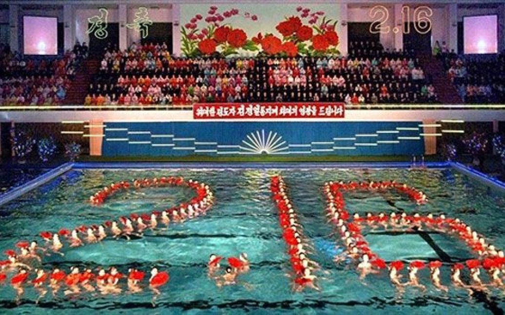 КНДР, Пхеньян. Синхронні плавці виступають під час у басейні оздоровчого комплексу Changgwang на святкуванні дня народження північнокорейського лідера Кім Чен Іра. Кім Чен Іру виповнилося 69 років. Фото AFP / KCNA via KNS" / © AFP
