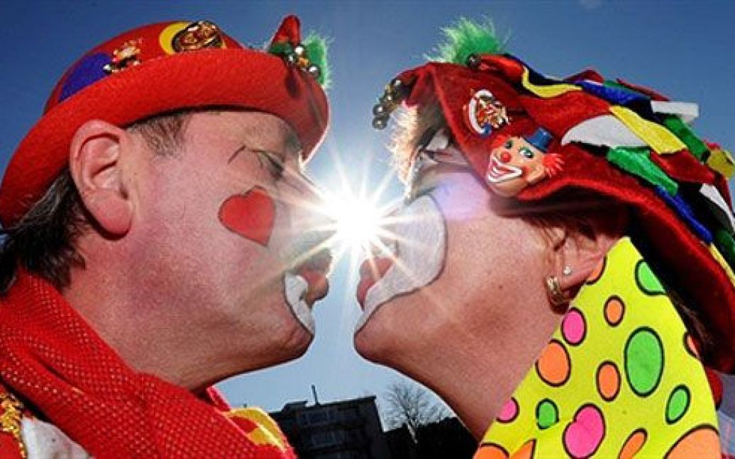 Німеччина, Дюссельдорф. Клоуни цілуються під час проведення традиційного параду на честь "Понеділка троянд" у Дюссельдорфі, Західна Німеччина. / © AFP