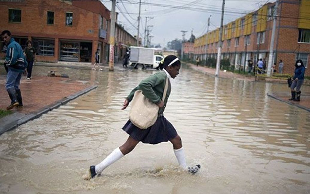 Колумбія, Богота. Школярка біжить через затоплену вулицю на околиці
Боготи, Колумбія. Мешканців житлового сектора Боза, на півдні Боготи,
було евакуйовано зі їхніх будинків після того, як сильні дощі
викликали переповнення річок в столиці Колумбії. / © AFP