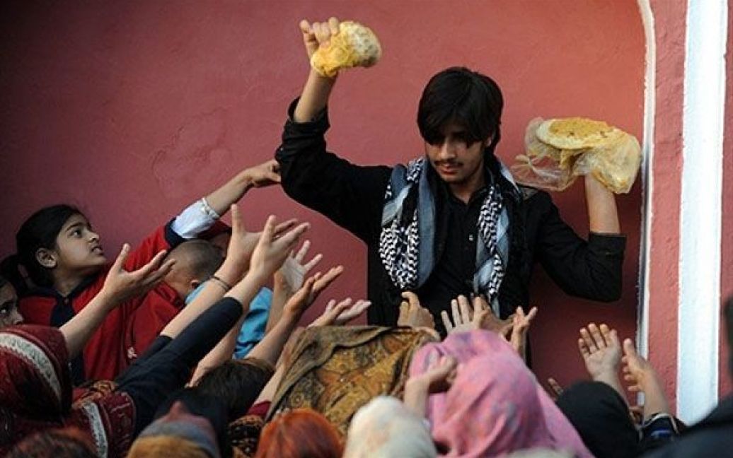Пакистан, Лахор. Пакистанець роздає їжу мусульманським відданим у храмі святого суфія Міана Світ Сахіба під час відзначення його 367-ої річниці смерті у Лахорі. У дводенній події з цього приводу взяли участь тисячі відданих. / © AFP
