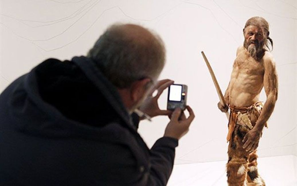 Італія, Больцано. Чоловік робить фотографію статуї "крижаної людини" на ім.&rsquo;я Еці, останки якого були виявлені у 1991 році між Австрією та Італією в гірському льодовику і добре збереглися. Вік Еці, статуя якого виставлена у Археологічному музеї, склав близько 5 300 років. / © AFP