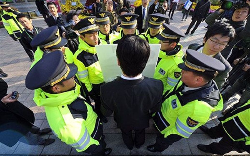 Республіка Корея, Сеул. Південнокорейського демонстранта оточили співробітники поліції під час його самотньої акції протесту проти одного з урядових проектів перед місцем проведення саміту G20 у Сеулі. / © AFP