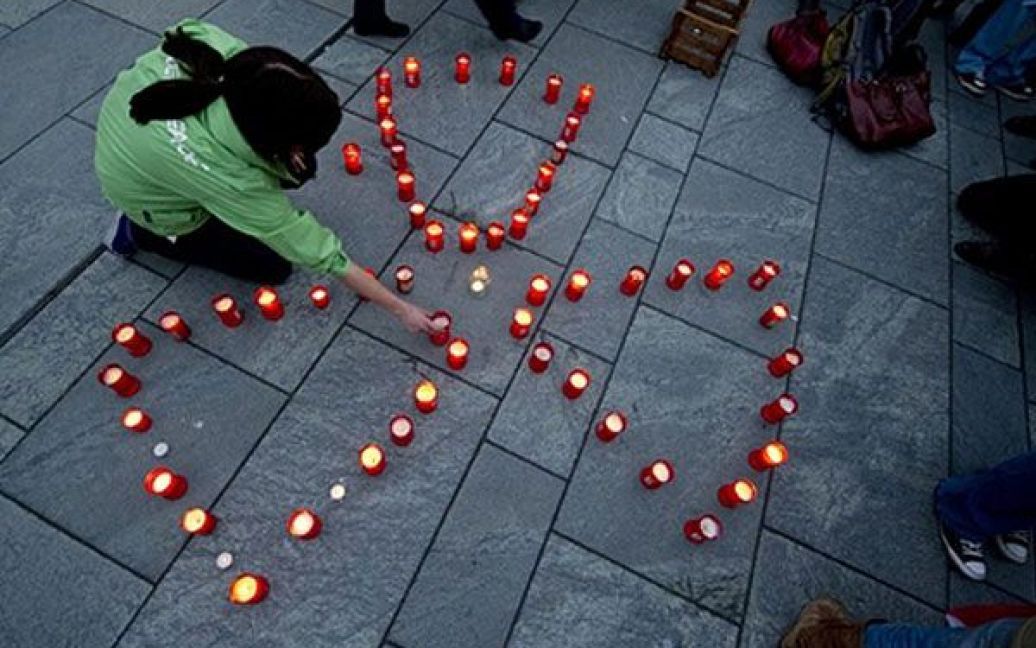 Німеччина, Берлін. Активіст руху "Грінпіс" запалює свічки у формі ядерного символа під час антиядерної демонстрації в Берліні. Федеральний канцлер Німеччини Ангела Меркель заявила, що у країні незабаром будуть тимчасово відключені від мережі сім АЕС. / © AFP