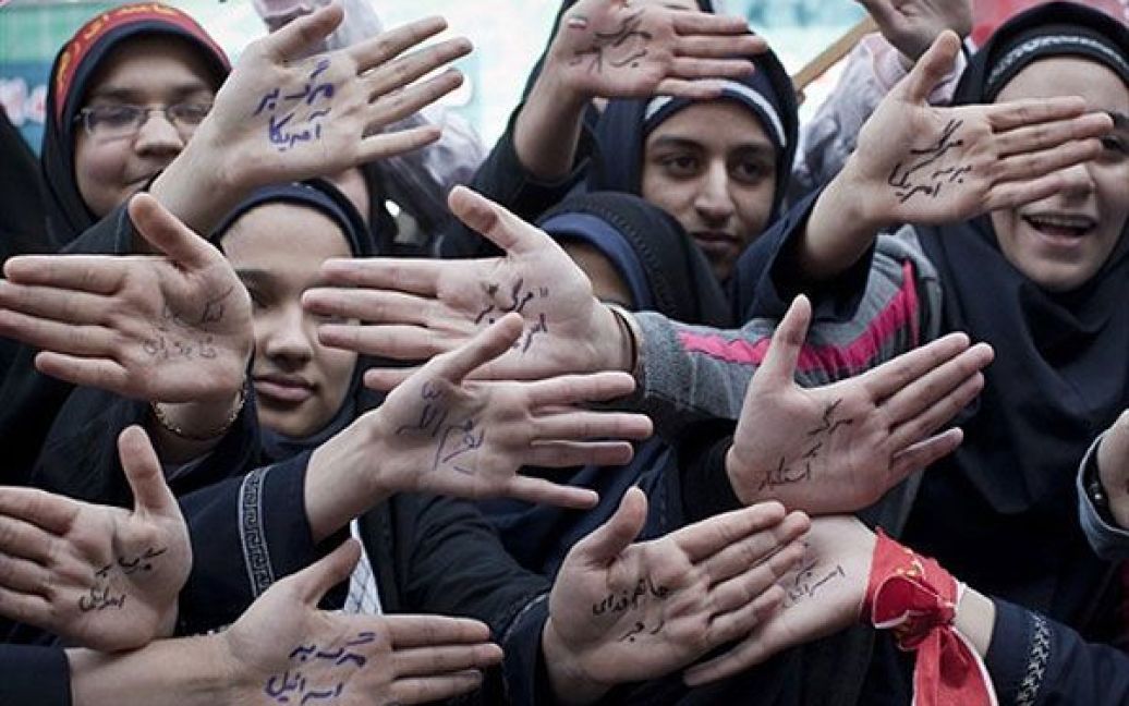 Іран, Тегеран. Іранські жінки і школярки показують свої долоні, на яких написані антиамериканські, антиізраїльські і антиурядові гасла, під час мітингу перед колишнім посольством США у Тегерані. Таким чином вони відзначили 31-у річницю захоплення посольства ісламістськими студентами. / © AFP