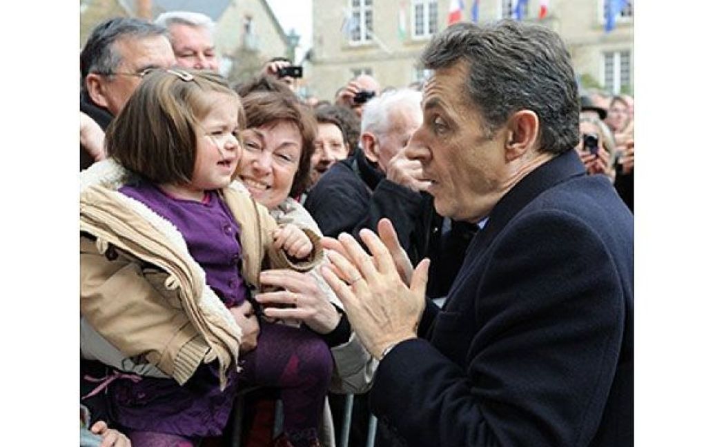Франція, Жослен. Президент Франції Ніколя Саркозі реагує, коли маленька дівчинка, яку він хотів поцілувати, почала кричати та ручатися. Саркозі у місті Жослен провів зустріч з мерами регіону Морбіан. / © AFP
