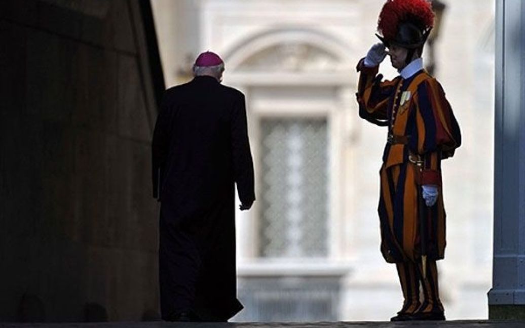 Ватикан. Швейцарський гвардієць салютує єпископу, який прямує на загальну щотижневу аудієнцію до Папи Римського Бенедикта XVI. / © AFP