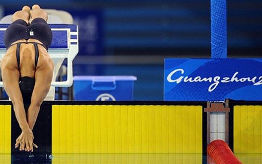 Китай, Гуанчжоу. Японська спортсменка Юка Като змагається під час запливу на 100 м стилем батерфляй на 16-их Азіатських іграх у Гуанчжоу. / © AFP
