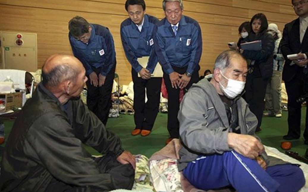Японія, Тамура. Віце-президент компанії TEPCO Норіо Цузумі просить вибачення у літніх людей, яких евакуювали з їхніх домівок через аварію на АЕС "Фукусіма-1". Цузумі відвідав кілька евакуаційних центрів у префектурі Фукусіма і вклонився кожному з постраждалих. Фото AFP/YOMIURI SHIMBUN / © AFP