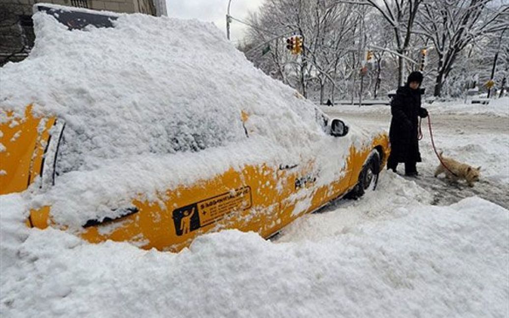 США, Нью-Йорк. Занесене снігом нью-йоркське таксі стоїть на 5-ій авеню. Деякі регіони Сполучених Штатів потерпають від потужних снігопадів і сніжної бурі. Всі державні школи Нью-Йорка були закриті через надзвичайні погодні умови. / © AFP