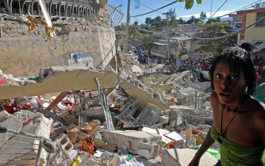 Наступний день після катастрофічного землетрусу на Гаїті. Дівчина йде по уламках торгового центру у Порт-о-Пренс. (THONY BELIZAIRE / AFP / Getty Images) / © The Boston Globe
