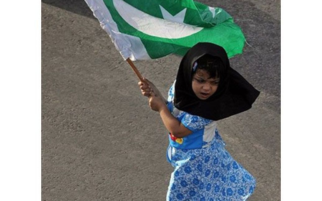 Пакистан, Карачі. Дівчинка розмахує пакистанським національним прапором під час акції протесту у Карачі на підтримку повалення режиму Хосні Мубарака у Єгипті. / © AFP