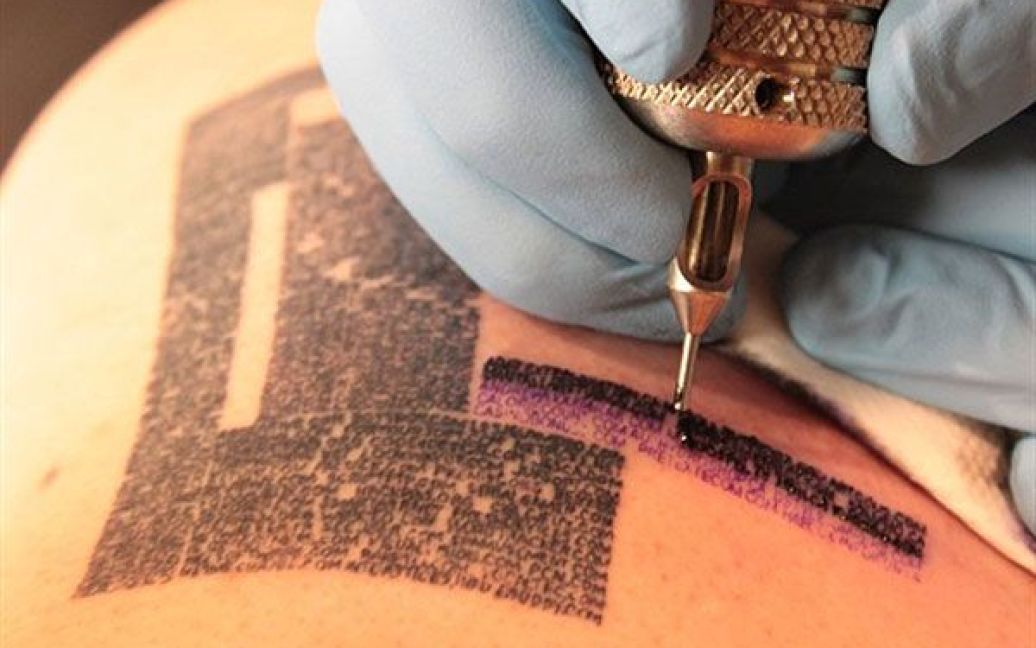 Канада, Монреаль. Майстер Даніель Тремблей робить татуювання з інтернет-адресою Патріку Вальянкуру. Вальянкур планує зробити татуювання більше 100 тисяч інтернет-адрес на своєму тілі протягом року, продаючи місце на своїй шкірі за 35 доларів США за адресу. / © AFP