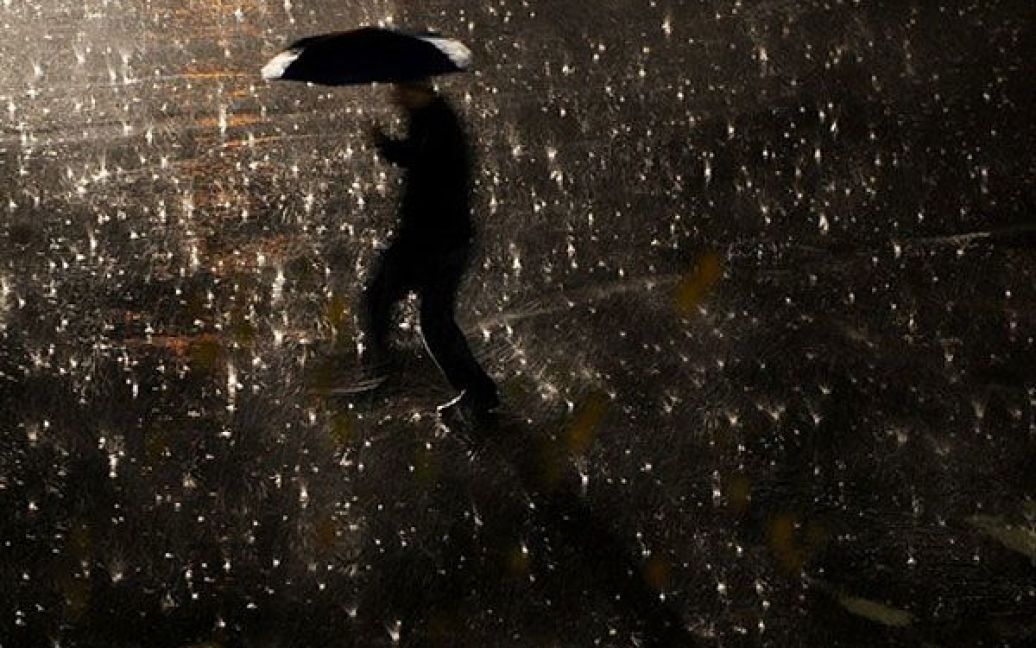 Сербія, Пріштіна. Чоловік із парасолькою йде під час сильного дощу вулицею міста Пріштіна, Косово. / © AFP