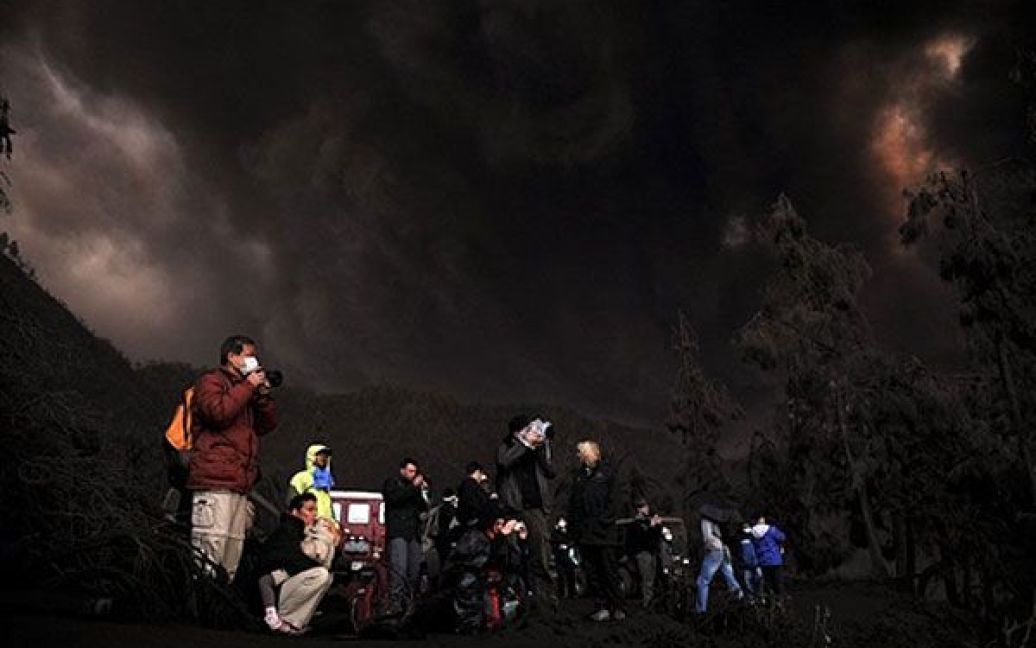 Індонезія, Чеморо Лаванг. Іноземні туристи фотографують виверження вулкана Бромо на сході індонезійського острова Ява. Вулкан Бромо прокинувся наприкінці листопада, а виверження почалось 19 грудня. / © AFP