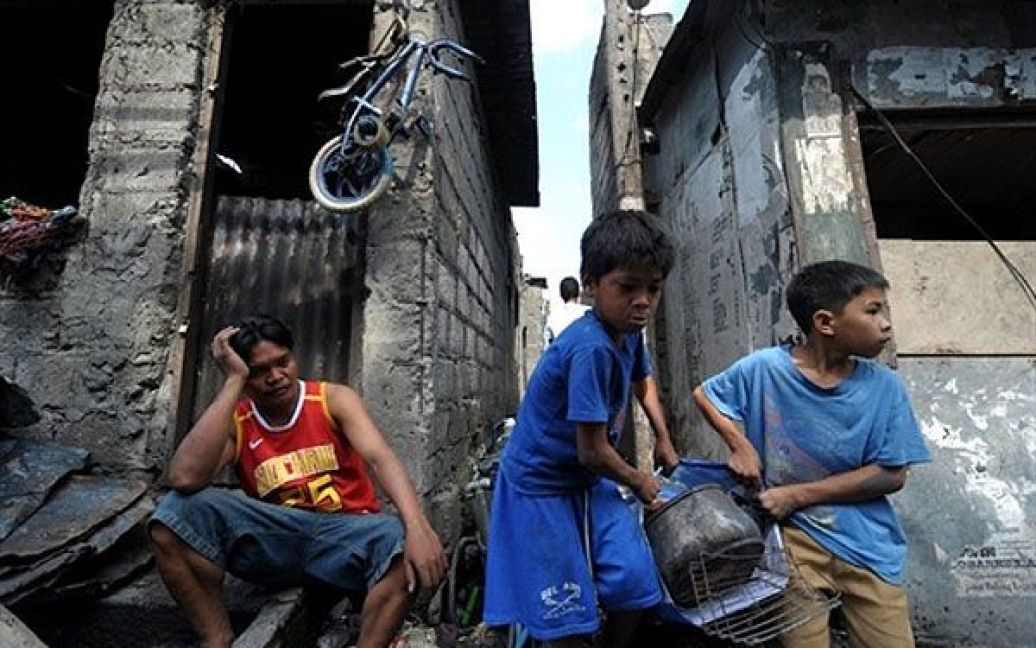 Філіппіни, Маніла. Діти збирають речі, що вціліли після нічної пожежі у нетрях Маніли. В результаті пожежі 12 людей загинули, були зруйновані близько 100 будинків. / © AFP
