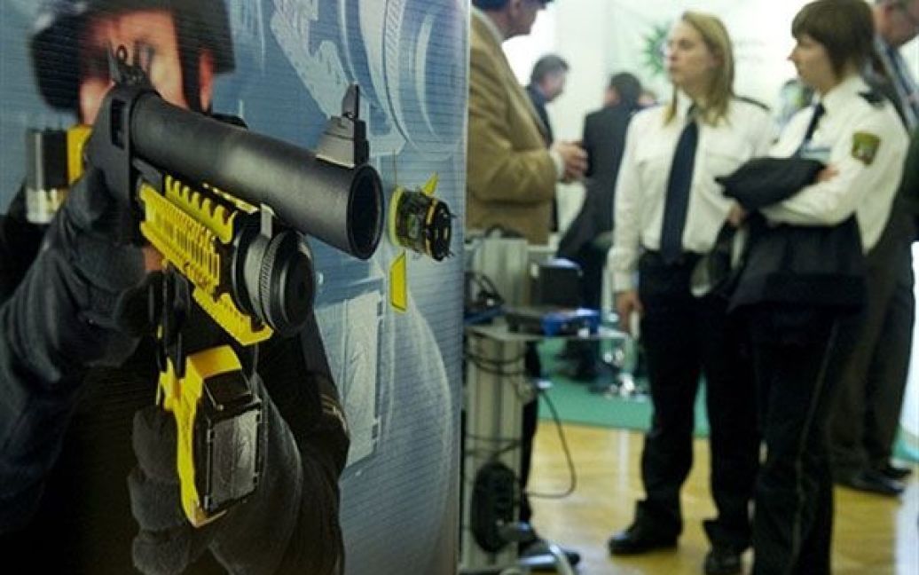 Німеччина, Берлін. Рекламний плакат кулемета Taser X-12, на який можуть встановлюватися електронні пристрої Taser XREP від виробника зброї "Мосберг", вивішено на стенді Taser під час Європейського поліцейського конгресу в Берліні. / © AFP