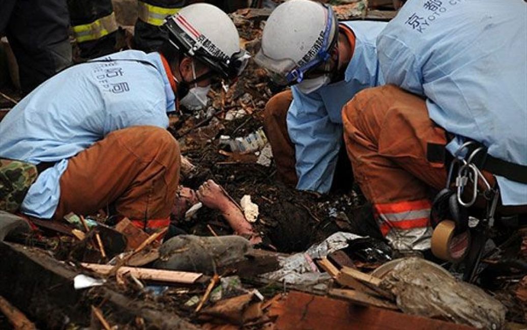 Японія, Мінамісанріку. Японські пожежні витягують тіло жертви з-під уламків будинку в місті Мінамісанріку в префектурі Міягі, яка найбільше постраждала від стихії. / © AFP