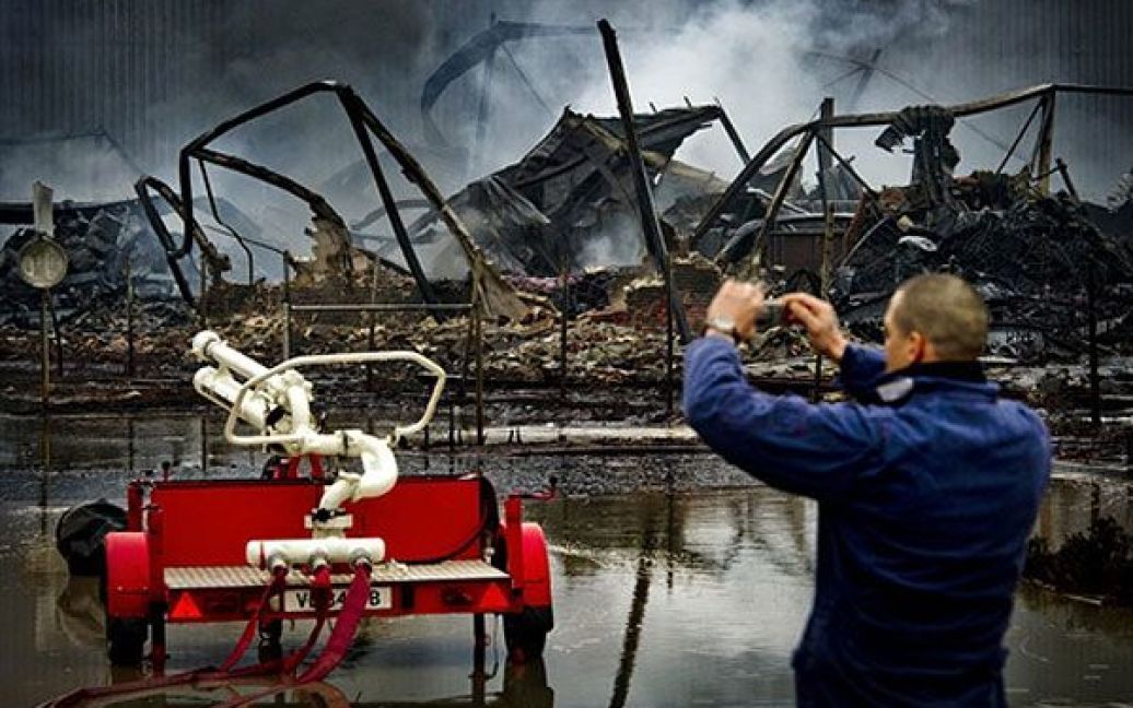 Нідерланди. Чоловік фотографує залишки хімічного заводу "Chemie-Pack" неподалік від Роттердама, який згорів вщент в результаті величезної пожежі. Пожежа на заводі, де зберігаються близько 400 тисяч літрів канцерогенного матеріалу, тривала кілька годин. / © AFP